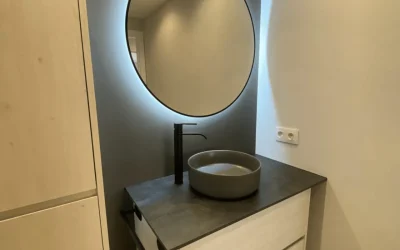 Lavabo de baño moderno con espejo circular iluminado